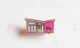 small enamel pin in the shape of a palm springs modern home