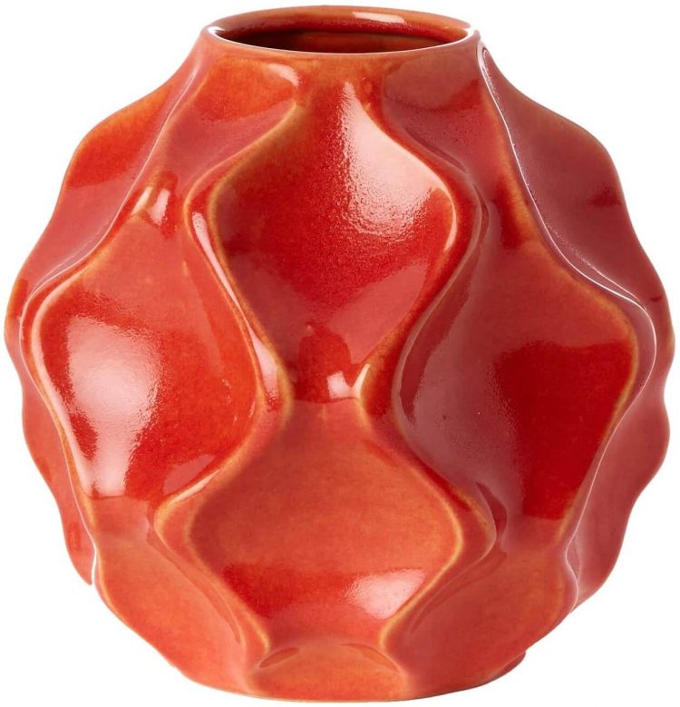 A red mid century vase with a wavy design scheme.