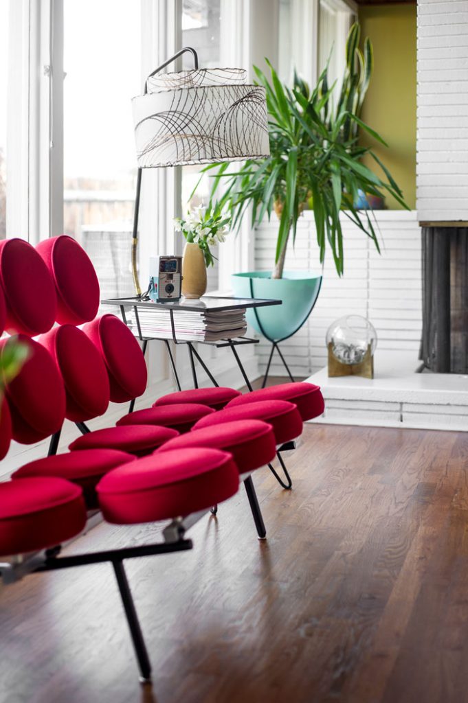 A bright red George Nelson Marshmallow Sofa is undoutedly the star of the show—perfectly accented by the vintage side table that does triple duty as a magazine rack and lamp.