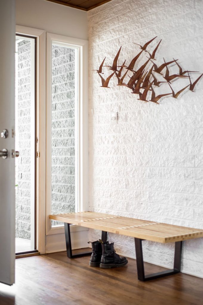 A George Nelson bench and Curtis Jere bird sculpture give guests a midcentury greeting at the entryway of the house.