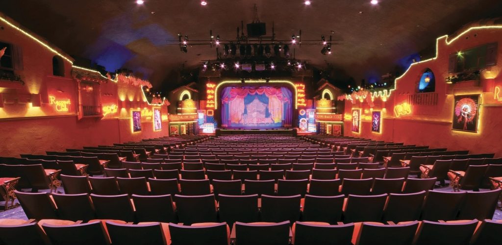 The plaza theatre interior detailing its red chairs and expansive hall.