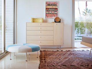 girard color wheel ottoman in a bedroom with a natiraul birch dresser and girard font art on the wall bedroom.