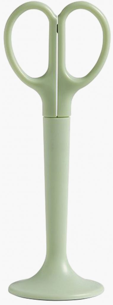 Mint-colored scissors sit upright in a matching stand.