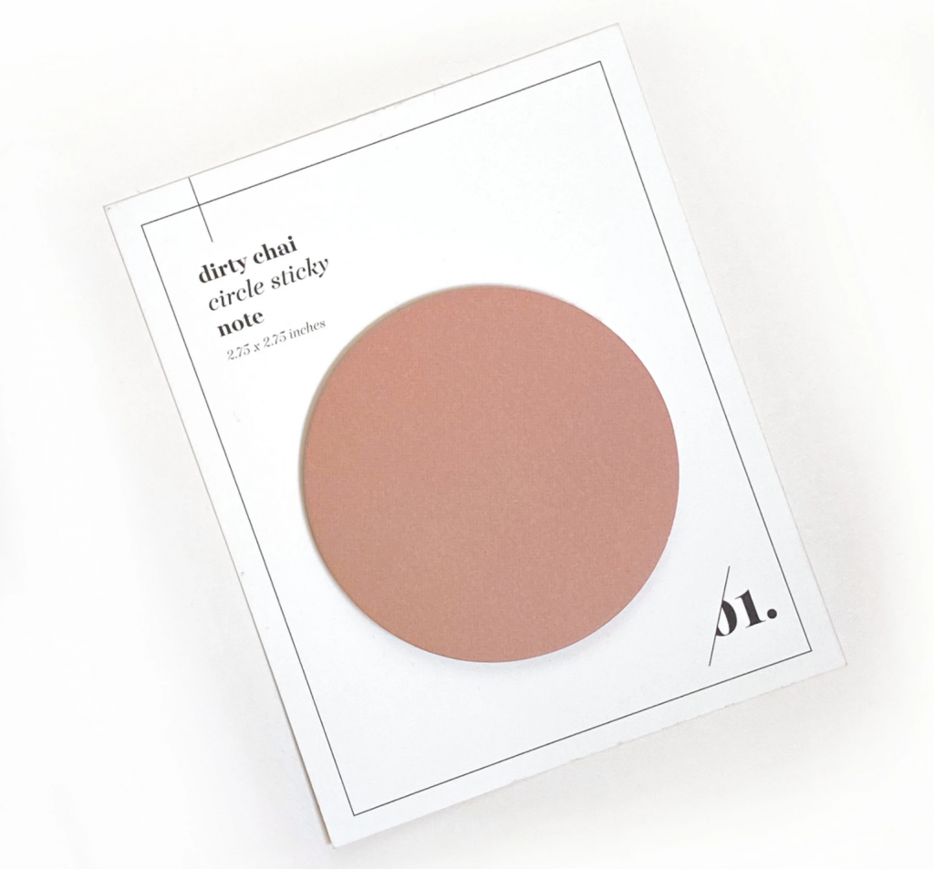 A chai-colored circular sticky pad sits on a white card backing