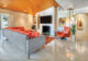 Mid Century Modern living room with paneled ceilings, terrazzo flooring and orange furniture and accents