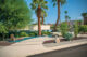 William Krisel's Palm Springs home exterior with palm trees and a retro vehicle
