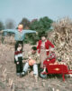 mid century family in field with pumpkins