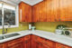 mid century kitchen with green backsplash and wooden cupboards