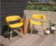 Two outdoor yellow ribbon chairs sitting on a deck.