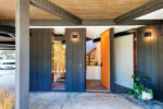 Bright orange front door on the ground level of Mid Century California home