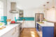 renovated kitchen with teal geometric backsplash and blue island cabinetry