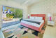 colorful wallpaper and pink upholstered bedframe in Twin Palms home