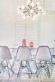 white dining room with sputnik chandelier and pink accents