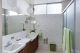 Mid century bathroom in Pierre Koenig home with floral wallpaper and green accents