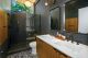remodeled bathroom with terrazzo floor and black tile