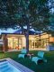 backyard of Austin architect's home at dusk with view to interior
