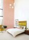 guest bedroom with yellow-green upholsetered headboard and pink graphic wallpaper
