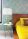 sunburst wallpaper turquoise and gold in bedroom with platform bed and funky lamp