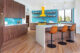 Michigan home with angled kitchen island, tile backsplash yellow range and hood
