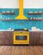 teal geometric backsplash tile and yellow range and hood in vibrant Michigan home