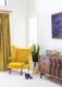 master bedroom with yellow MCM chair snake plant and MCM dresser