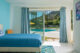 blue accent wall and bedding in bedroom that opens out to backyard pool