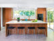 A large island and four barstools in a mid century modern kitchen