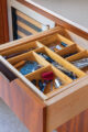 An open kitchen drawer that contains a bamboo insert filled with drink accessories