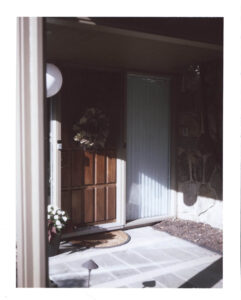 a wreath hangs on the front door of designer adrian pearsall's home