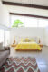 bedroom with yellow abstract bedding wooden sculptural table lamps and large clerestory windows