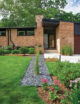 natural brick exterior with geometric lines of house continued into front yard hardscape
