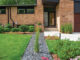 natural brick exterior with geometric lines of house continued into front yard hardscape
