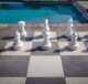 stone hardscaping around backyard pool with life size chessboard