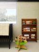 nursery with mid century inspired bookshelf and wooden kids' toy