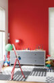 red accent wall in playroom with black and white patterned rug