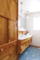 blue concrete tile in bathroom with wooden cabinetry
