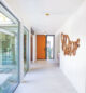 hallway with wall of windows and geometric wall art in renovated Eichler