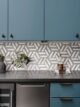 blue cabinetry with black and white hexagonal tile and thumbs up cabinet pulls