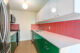 renovated mid century modern apartment with cork flooring, green shelving and pink backsplash tile