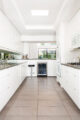 stark white galley kitchen with mounted appliances to free counter space