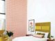 guest bedroom with green Arne Jacobsen egg chair colorful pink and coral wallpaper and chartreuse fabric headboard