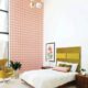 guest bedroom with green Arne Jacobsen egg chair colorful pink and coral wallpaper and chartreuse fabric headboard