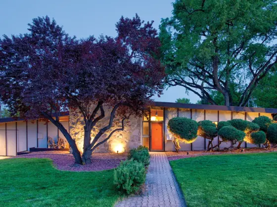 nighttime exterior view of 1957 Denver home with orange front door