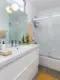 A look at the Palm Springs Vacation Rental bathroom which is all white. the bath rug is bright yellow. 