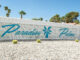 The Paradise Palms sign in blue in front of vintage breeze blocks