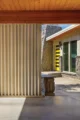 A view of the interior of a carport of a mid century modern house in Boise. A partition is visible which is made of a louvered aluminum.