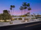 the exterior of a mod las vegas home featuring tall palm trees
