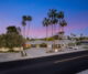 the exterior of a mod las vegas home featuring tall palm trees