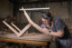 a woman working on a wooden chair
