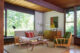 a mid century modern living room with exposed beam ceiling and a heywood wakefield living room set